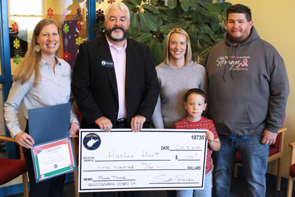 Huxley is pictured holding the large $100 check he was presented for winning the Chamber’s parade theme contest. Also pictured, standing behind him from left, are Marshall County Chamber of Commerce Board President Ashley Wear, Marshall County Chamber of Commerce Executive Director Scott Reager and Huxley’s parents Sarah and Justin Hart. 